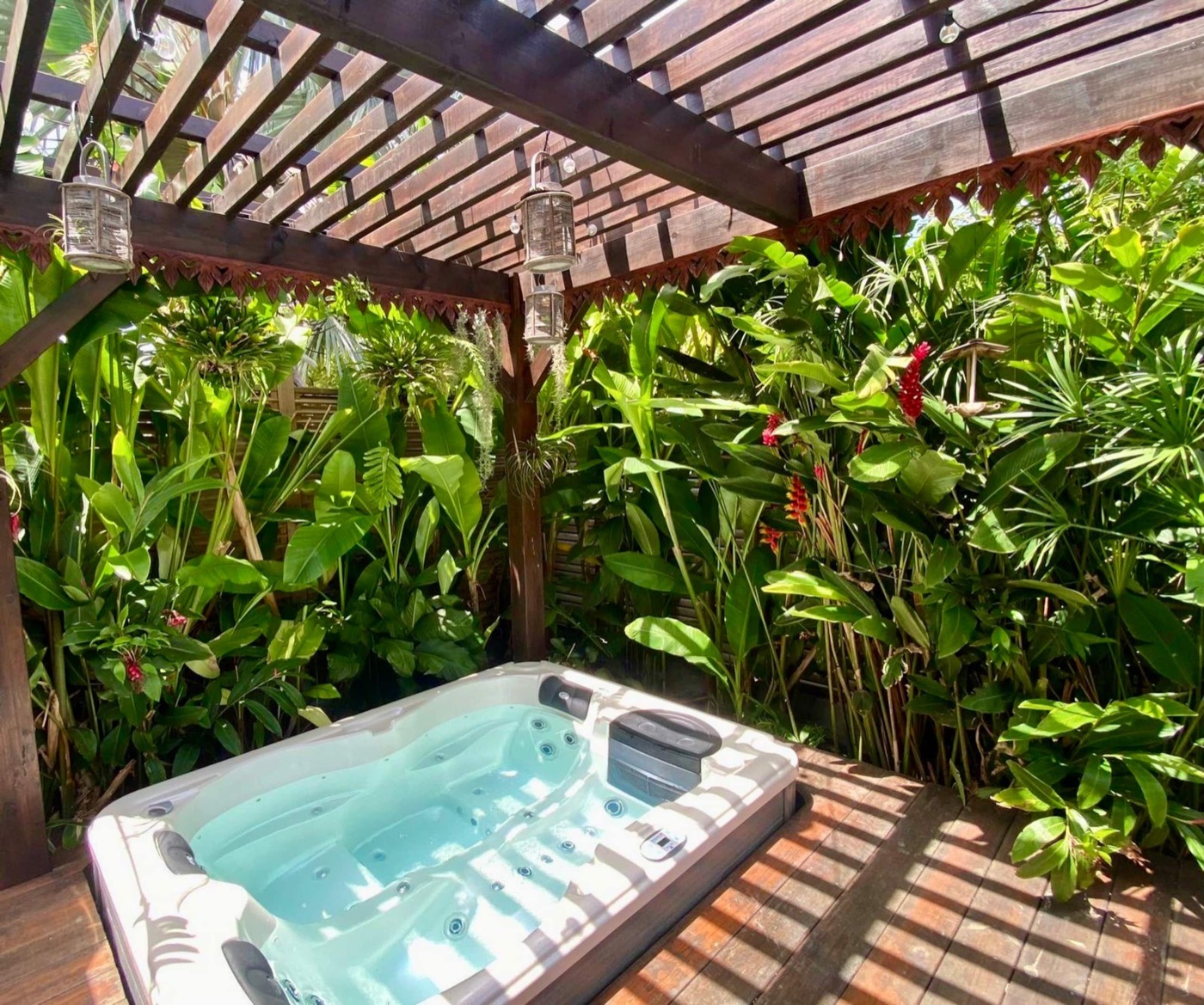 Jacuzzi sous la pergola, entouré du jardin tropical